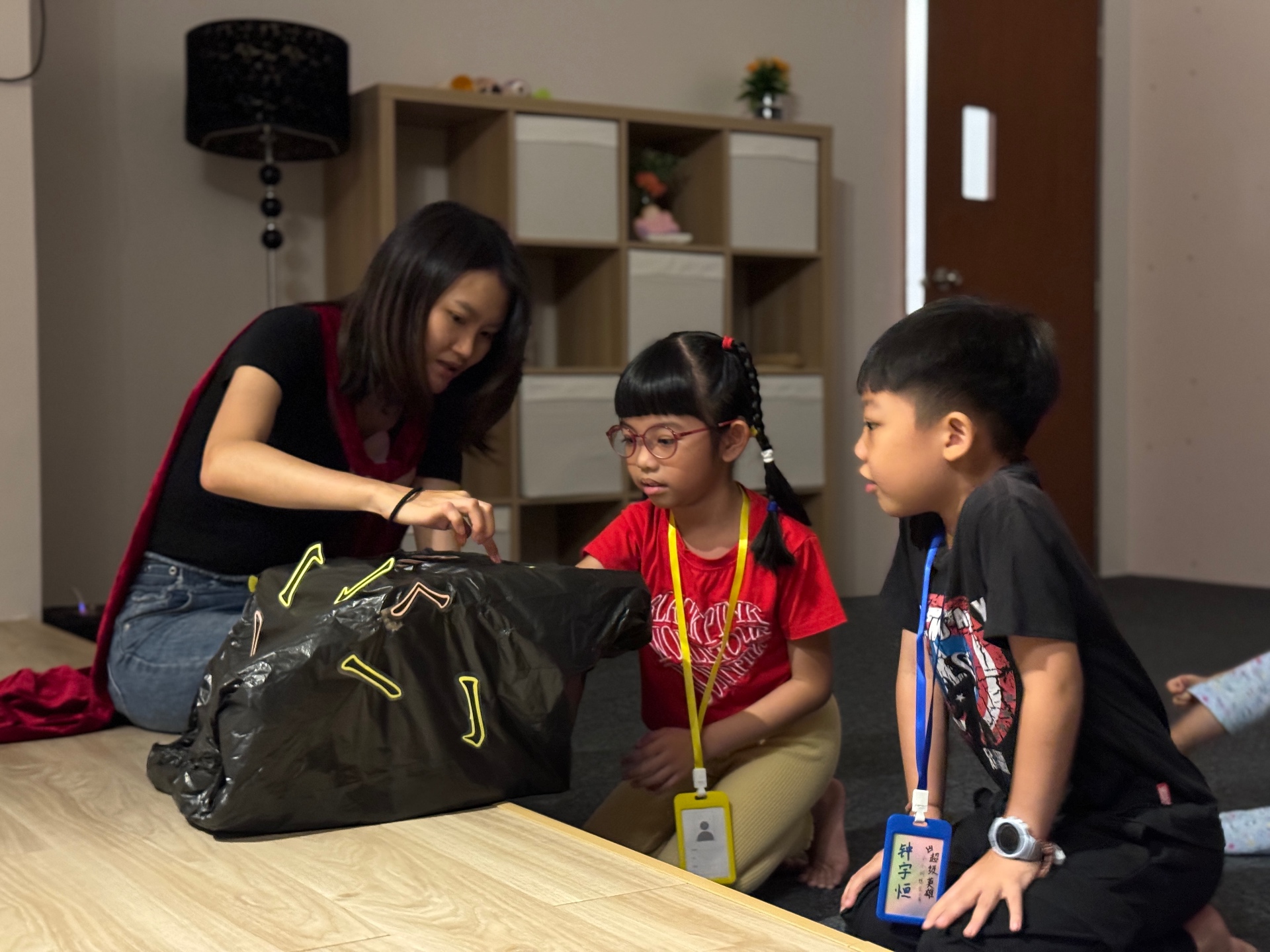 老师与两个孩子近距离互动，一起打开道具袋