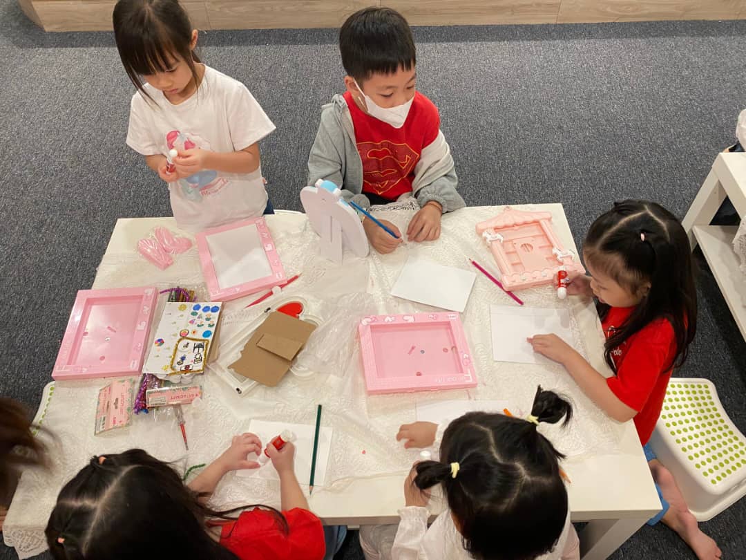 孩子们在桌上一起动手制作道具与作品的细节画面